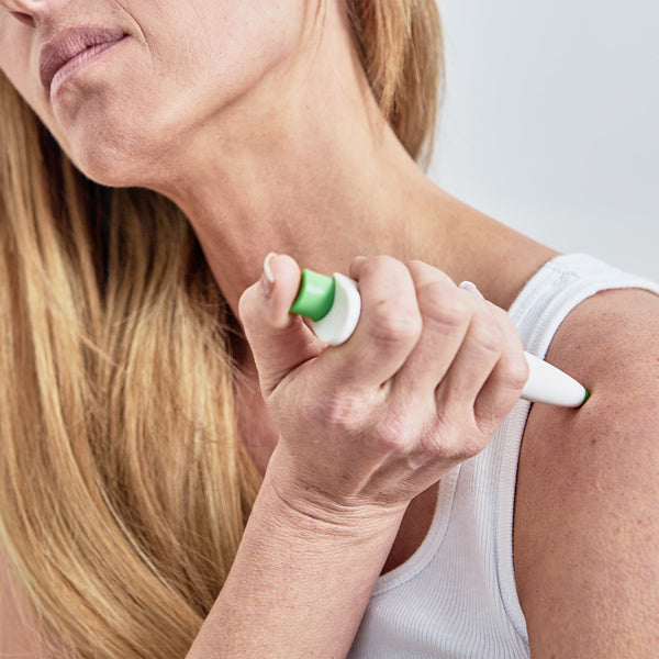 Woman using the Paingone One pen on her shoulder